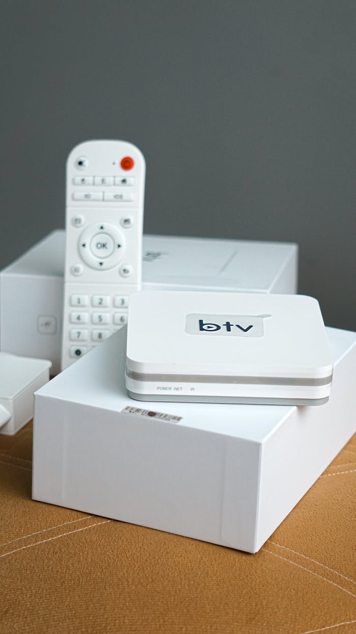 Home Vertical shot of a modern smart TV setup including a remote control and electronic device.